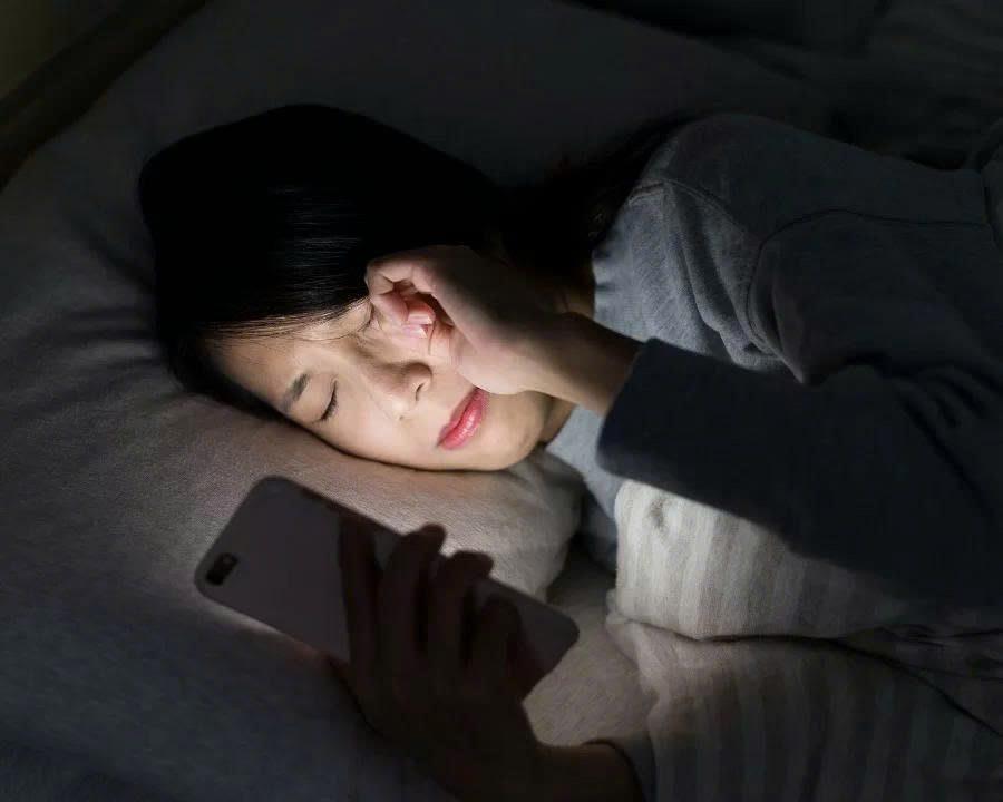 Hình ảnh minh họa mỏi mắt khi sử dụng điện thoại trong tối